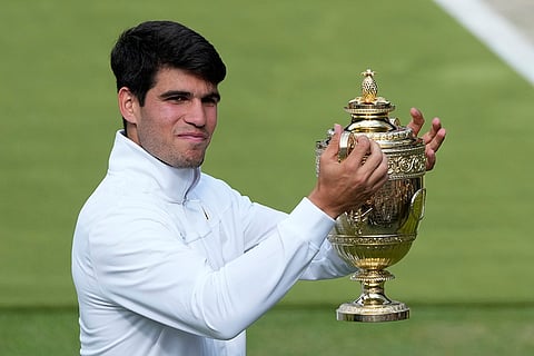 Carlos Alcaraz  holds up his trophy 
